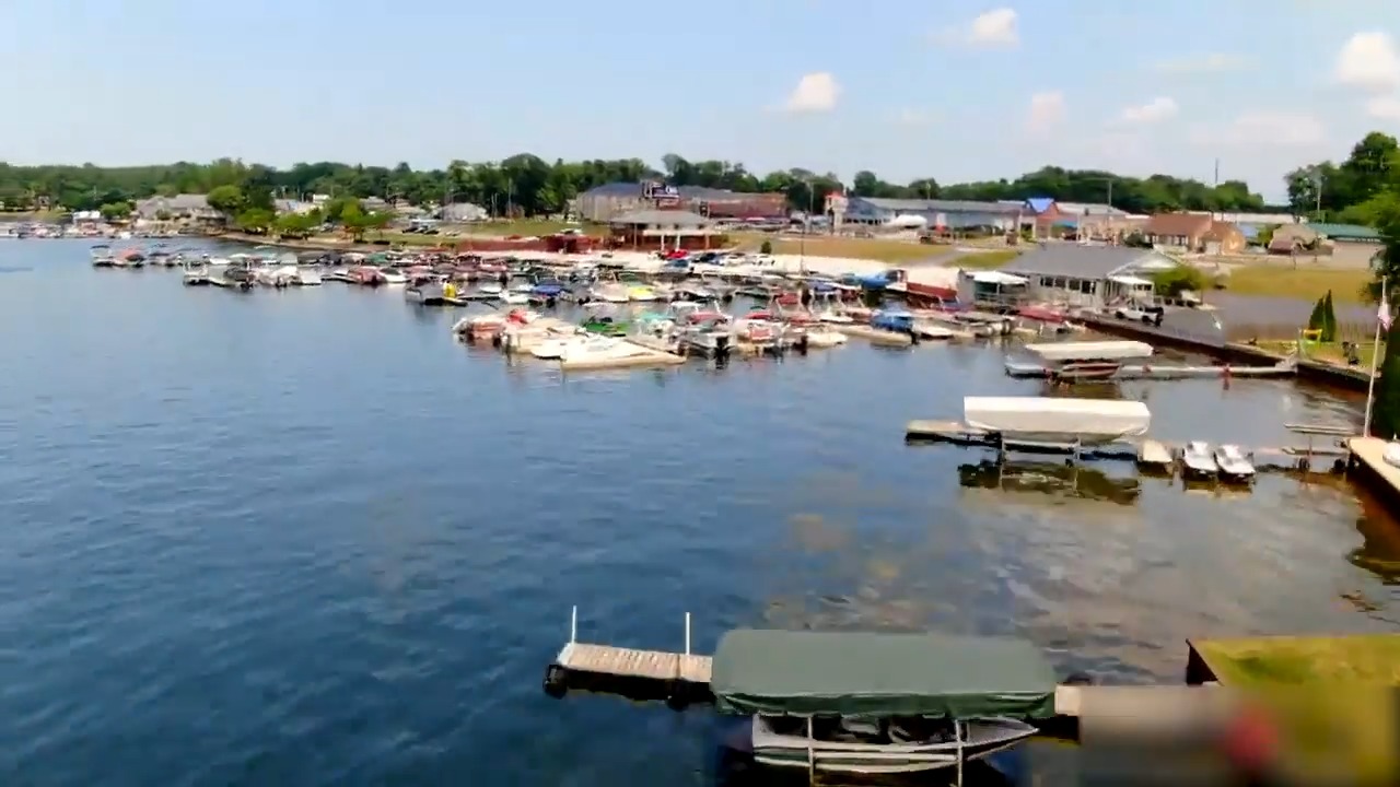 Aerial View Of Pine Lake Shoreline Filled With Boats And Houses In