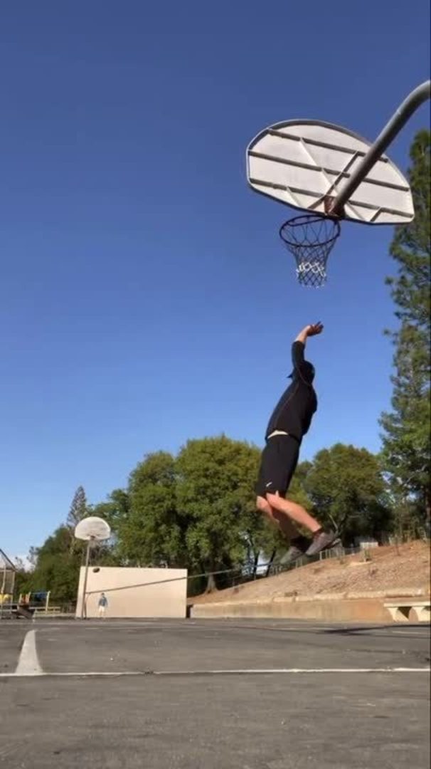 Guy Places Spinning Ball Atop Umbrella And Balances It In His Mouth